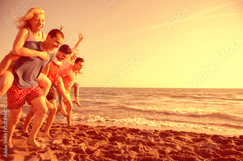 Friends fun on the beach under sunset sunlight © blicsejo