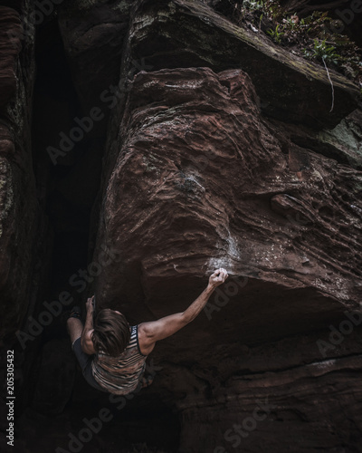 Mann beim bouldern am Fels 