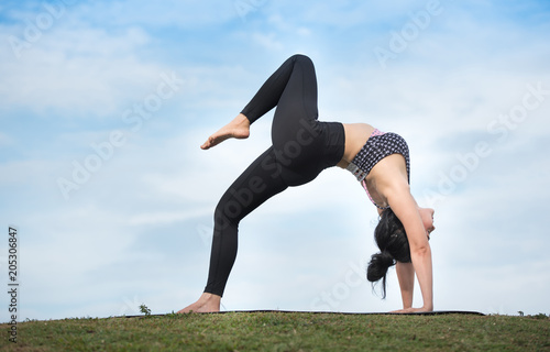 Beautiful woman practicing yoga in the park. © sunti