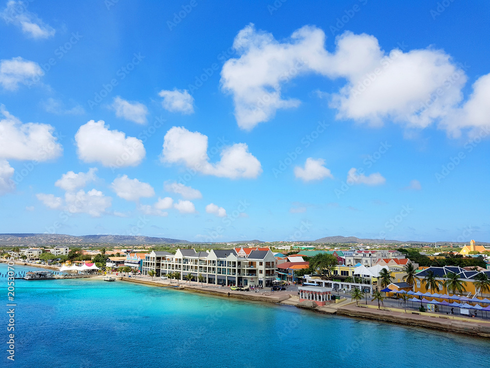 aerial view of the coastline city of Kralendijk, capital of Bonaire, with colorful buildings and blue sea and sky.