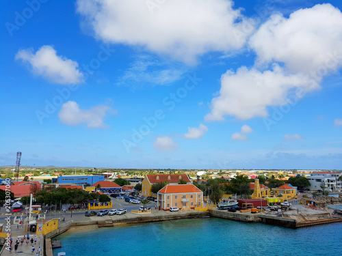 aerial view of the coastline city of Kralendijk, capital of Bonaire, with colorful buildings and blue sea and sky.