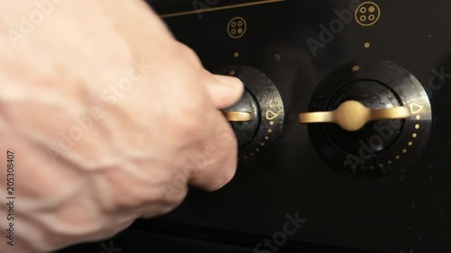 The Elderly Man Hand Turning Off Gas Stove photo