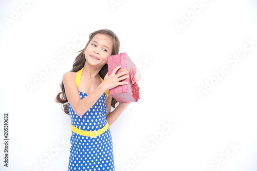 Young girl got suprise gift. Young cute white girl holding a red gift present box, looking funny and surprise. Isolated in white. Birthday girl and family concept.
