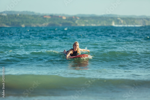 beautiful sportswoman swimming on surfboard in water © LIGHTFIELD STUDIOS