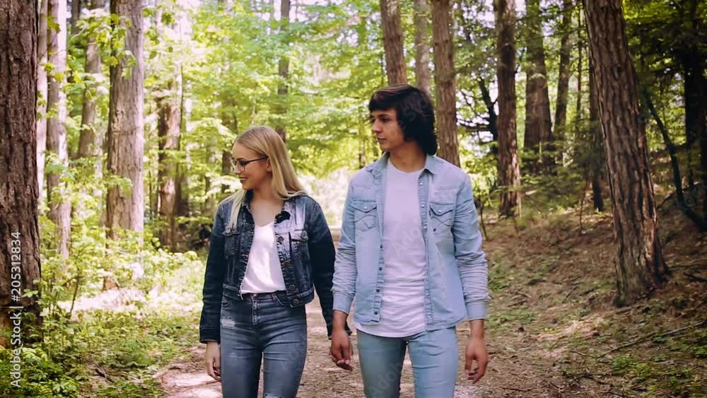 Young Couple Walking, Hand In Hand, Through Forest Young Couple Walking, Hand In Hand, Through Forest
