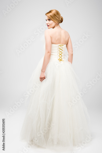 back view of bride in white wedding dress, isolated on grey