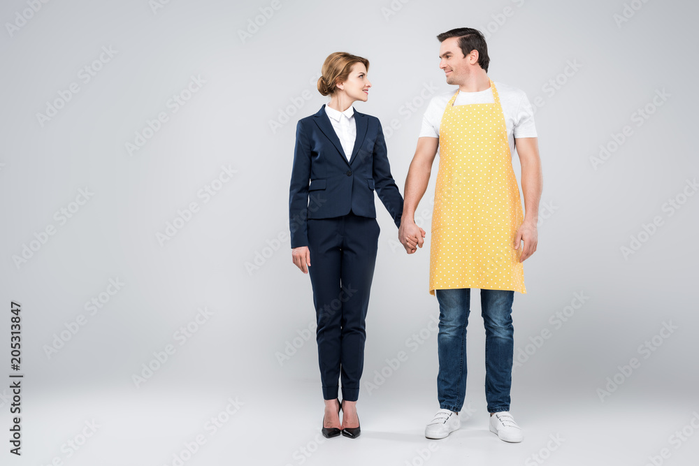 businesswoman in suit and male householder holding hands, feminism concept, isolated on grey businesswoman in suit and male householder holding hands, feminism concept, isolated on grey