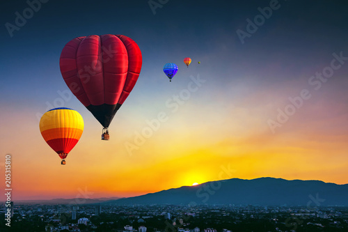 Aerial view colorful hot air balloons flying over Chiang Mai city in sunset ,Thailand..