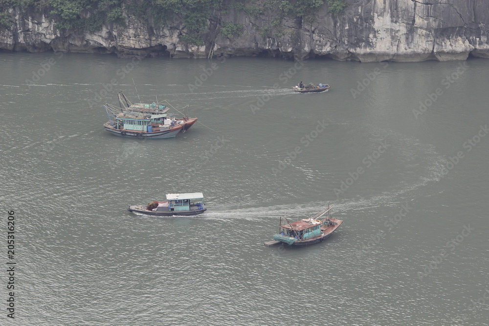 Obraz premium Ha Long Bay , Vietnam-29 November 2014:Fishing boat in Ha long Bay, Panoramic view of sunset in Halong Bay, Vietnam, Southeast Asia,UNESCO World Heritage Site