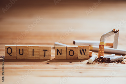 World No Tobacco Day, May 31. Close up Broken cigarette with QUIT NOW text on Wooden Block on wooden table background.