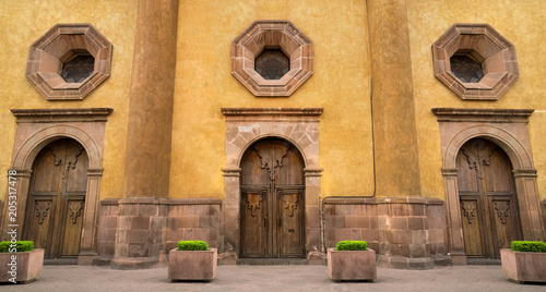 Mexican colonial style house in Queretaro Mexico, classic wood doors and decorative windows.