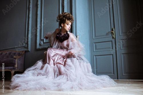 Fashionable female portrait of cute lady in pink dress indoors