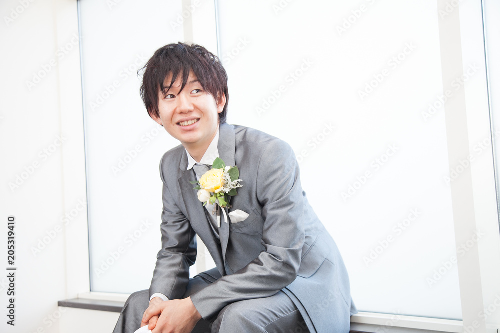 座って笑みを浮かべる新郎 座って笑みを浮かべる新郎