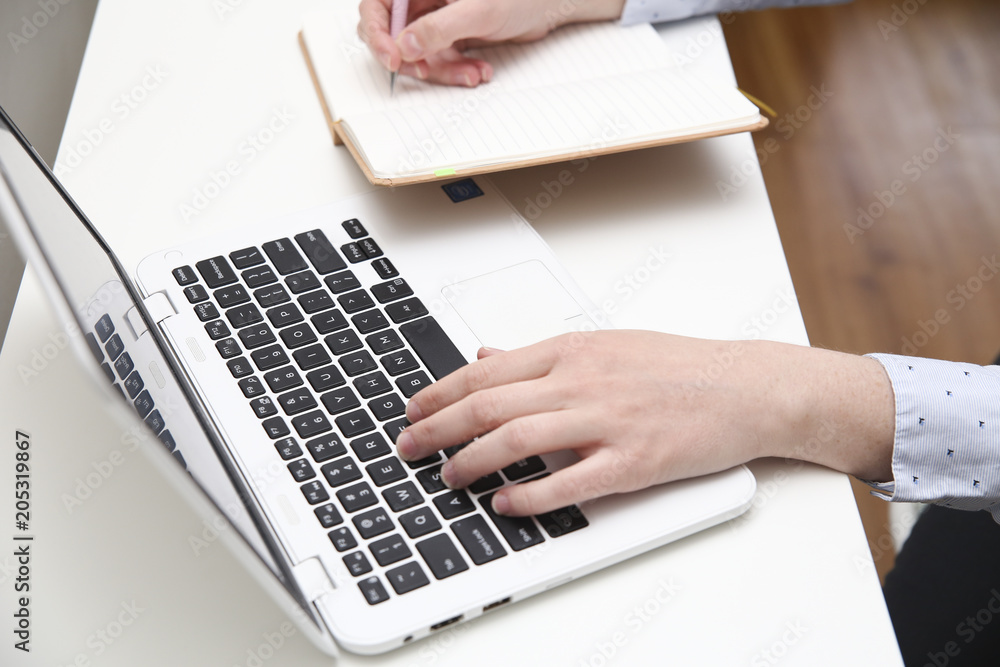 Close up of a person using white laptop at home office Close up of a person using white laptop at home office