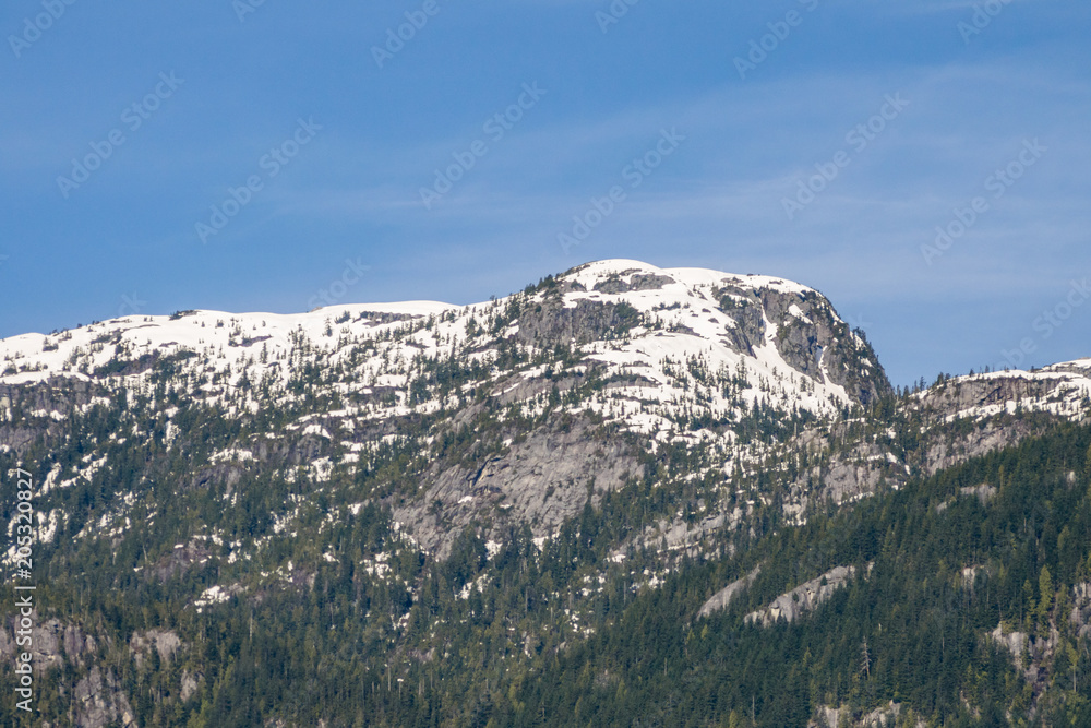 mountain range covered by snow in early spring under the blue sky