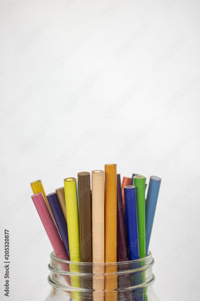 A jar of colored pencils on an isolated white background with room for text A jar of colored pencils on an isolated white background with room for text