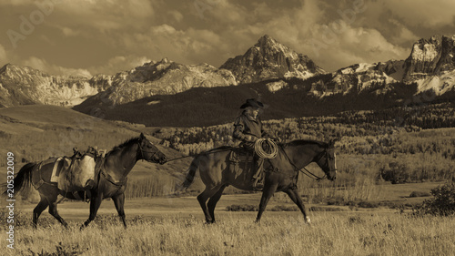 Older Cowboy leads packhorse across historic Last Dollar Ranch on Hastings Mesa  SW Colorado  San Juan Mountains