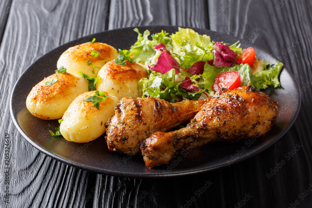 Hot grilled chicken legs with potatoes and fresh salad close-up. horizontal Hot grilled chicken legs with potatoes and fresh salad close-up. horizontal