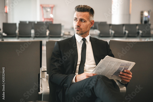 Serious businessman reading newspaper