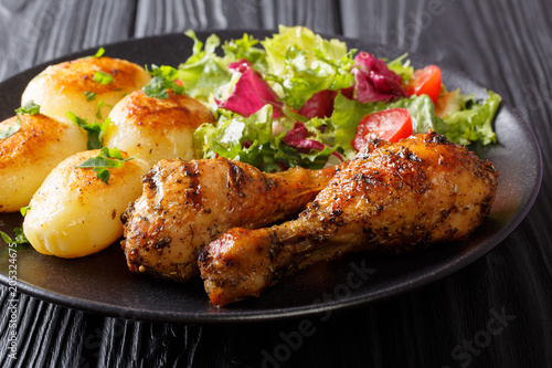 Delicious lunch: grilled chicken legs with potatoes and fresh salad close-up. horizontal