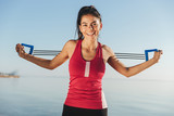 Happy sports woman doing exercise with hand expander