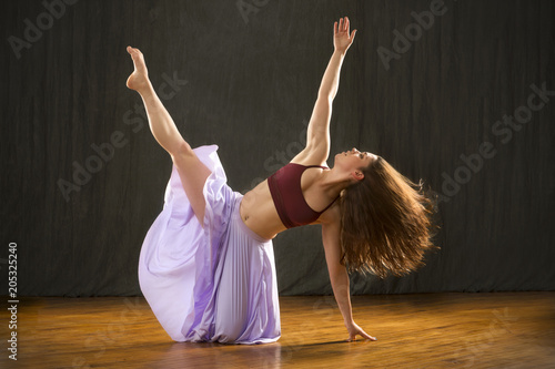 Young woman dancer performing dramatic floor work. photo