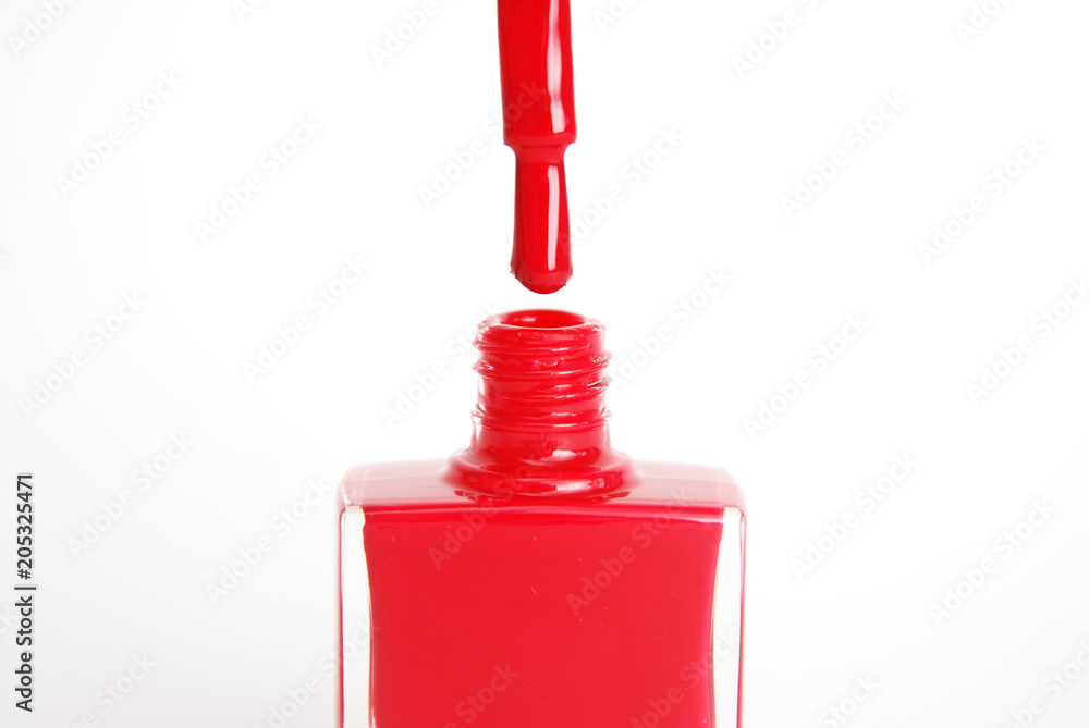 Fototapeta premium Nail Red Polish Flowing from the Bottle on White Background Beauty Fashion