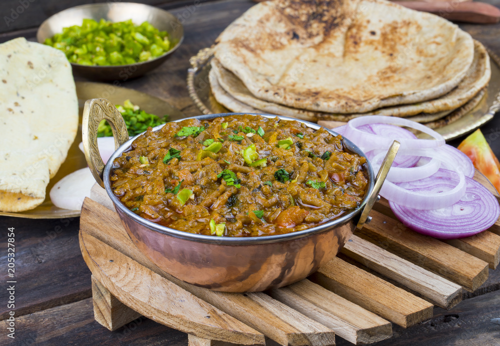 Indian Cuisine Sev Tamatar Also Called Sev Tamaeta or Sev Tameta is Served With Chapati, Papad, Onion or Raita. It is Made With Tomato And Onion Gravy With a Twist of Spicy Sev on Wooden Table Indian Cuisine Sev Tamatar Also Called Sev Tamaeta or Sev Tameta is Served With Chapati, Papad, Onion or Raita. It is Made With Tomato And Onion Gravy With a Twist of Spicy Sev on Wooden Table