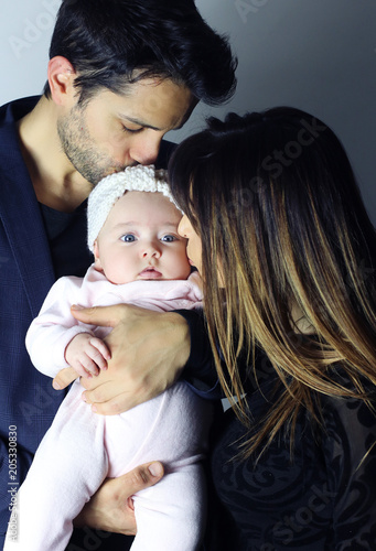 Une famille parfaite. jeunes parents embrassant leur bébé