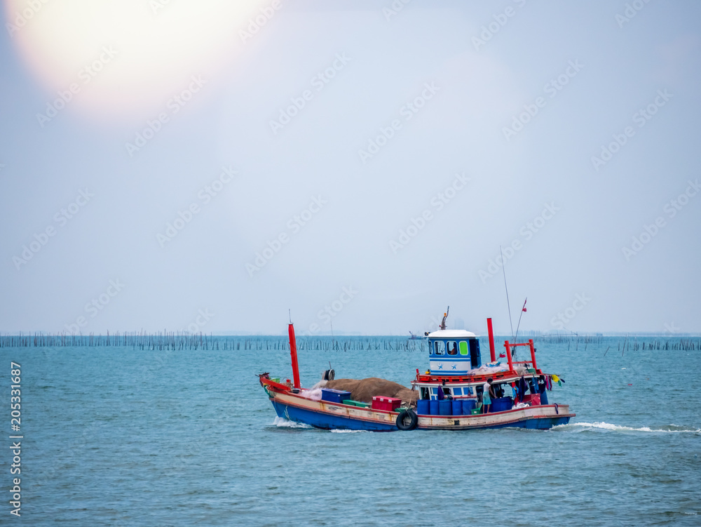 Fototapeta premium Thai fishing boat traditional used as a vehicle for finding fish in the sea at sunset.