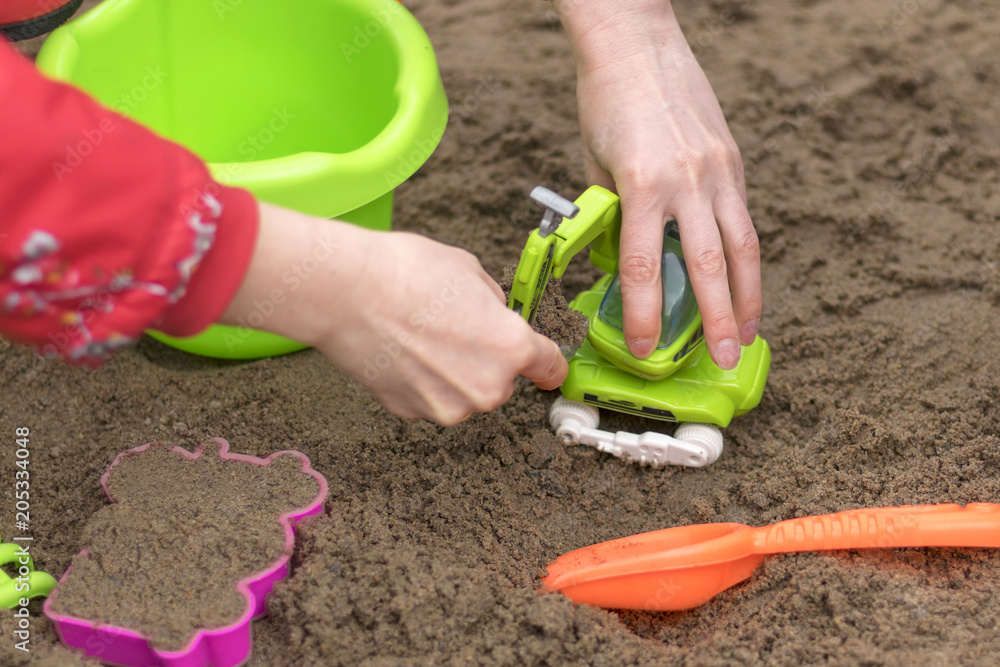 Children's sandbox, kids play sand building locks close-up