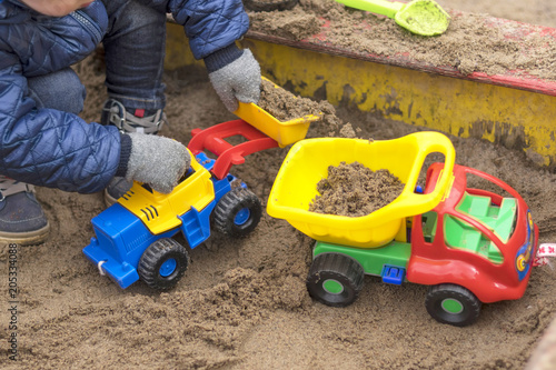 Children in warm winter clothes play in the sandbox close-up