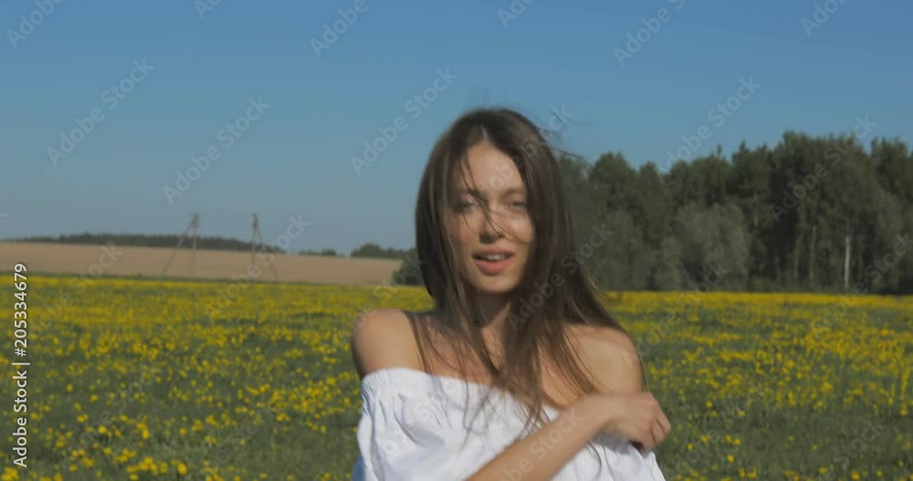 Attractive Young Woman Walks through the meadow and looks at Camera. Outdoor lifestyle portrait. 4K video shooting by handheld gimbal Attractive Young Woman Walks through the meadow and looks at Camera. Outdoor lifestyle portrait. 4K video shooting by handheld gimbal