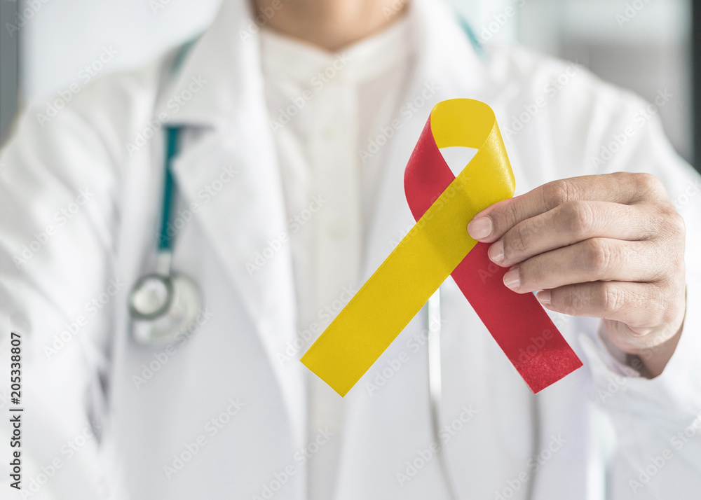 World hepatitis day and HIV/ HCV co-infection awareness with red yellow ribbon in medical doctor hand symbolic bow color to support patient with illness and hepatic disease - obrazy, fototapety, plakaty 