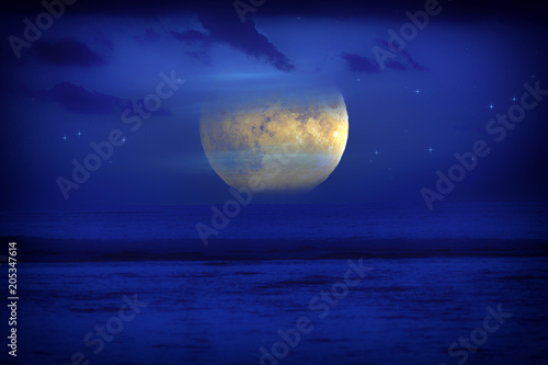 Exotic Moon and stars rising from the ocean horizon. 