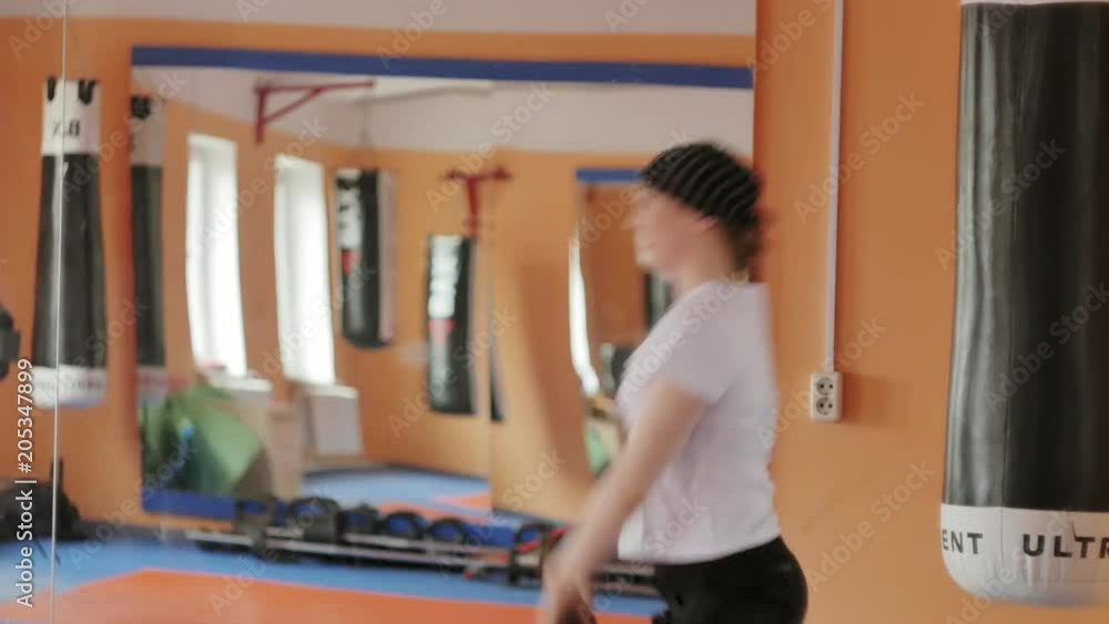 Woman kickboxer is training in a sports studio with dumbbells Woman kickboxer is training in a sports studio with dumbbells