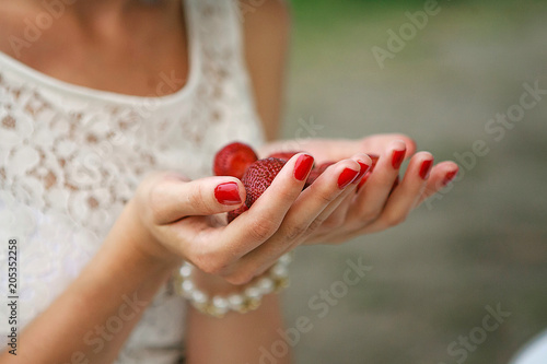Female hands hold a handful of strawberries