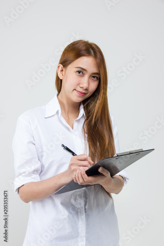 Asian businesswoman writing on clipboard