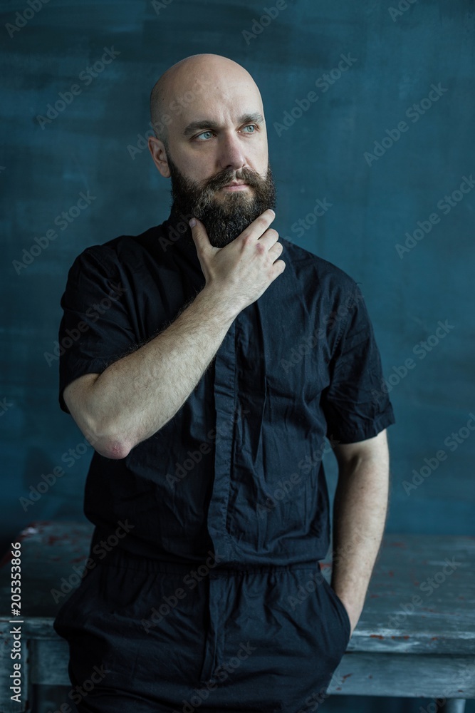 Young handsome bearded man posing against grunge wall background Young handsome bearded man posing against grunge wall background