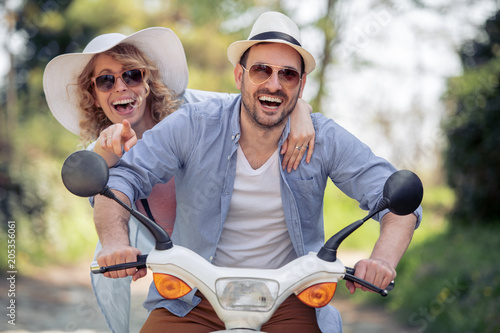 Cheerful young couple riding a scooter