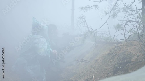 Soldiers in camouflage with combat weapons shoot at the forest shelter, military concept, smoke screen, fog photo