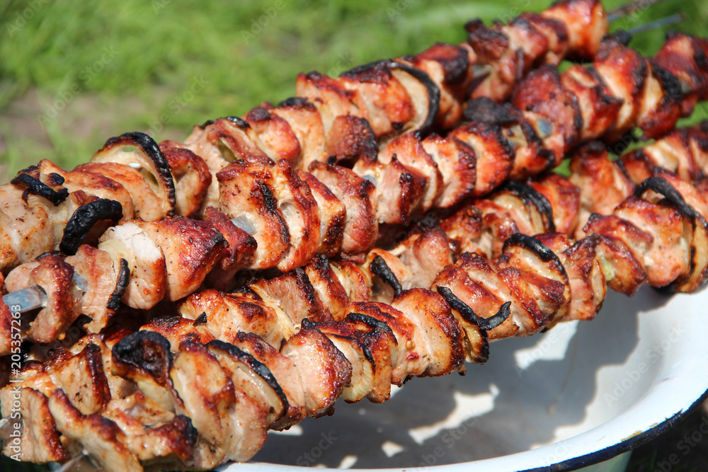 Appetizing shashlik on skewers on plate. Cooked pork meat. Barbecue lunch