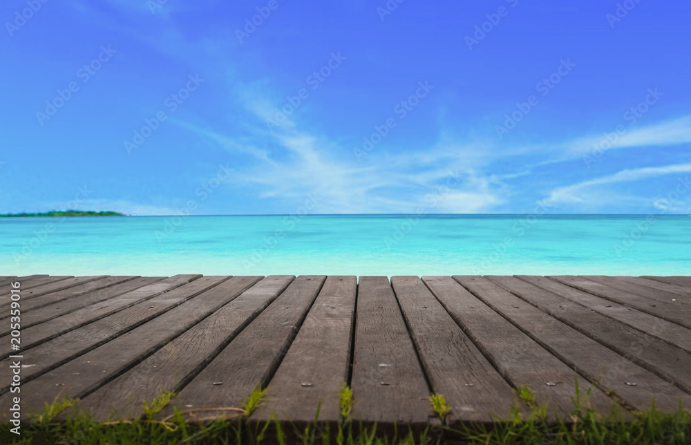 Blur cool sea background with foreground wood floor.