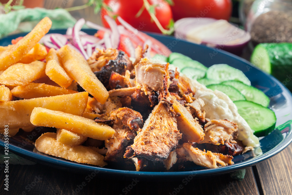Greek gyros dish with french fries and vegetables