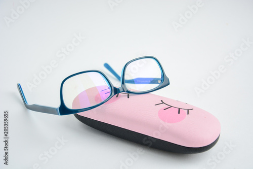 glasses rectangular in blue frame are located on the case for glasses