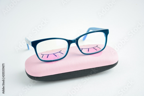 glasses rectangular in blue frame are located on the case for glasses