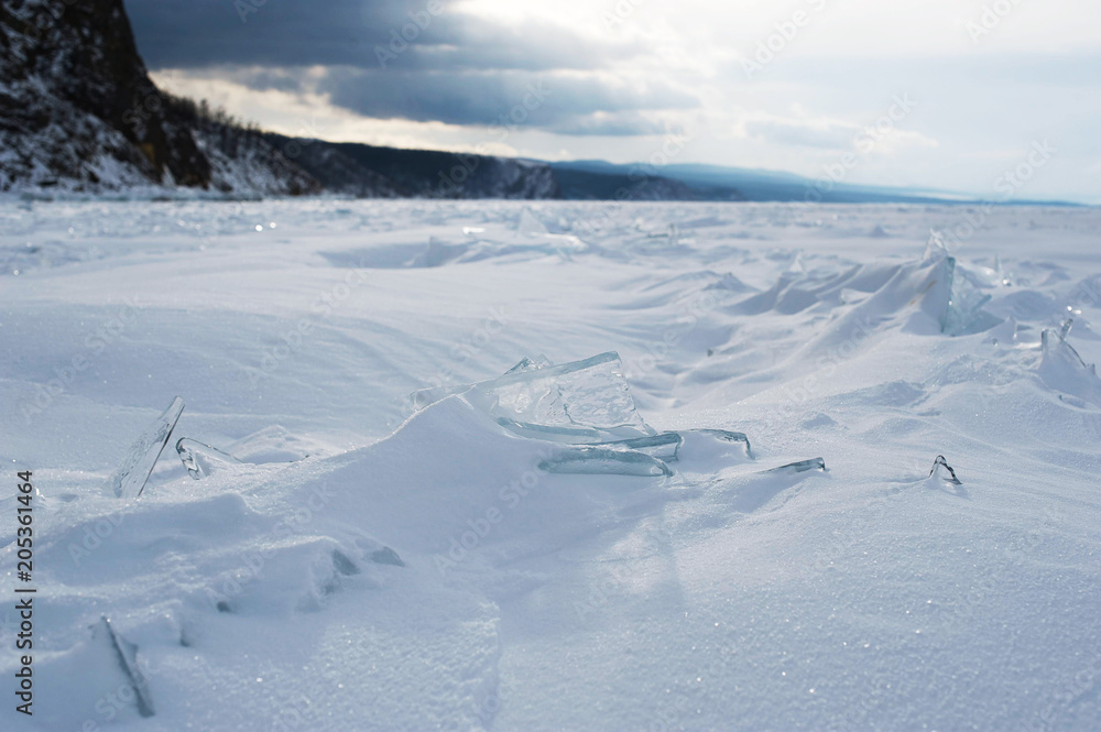 Winter landscape, Crystal clear ice chunks, icicles,Lake Baikal, Siberia, Russia. Sunny winter day weather, ice cracks, clear water, slippy and cold frozen ground.Beautiful wallpaper with nature scene Winter landscape, Crystal clear ice chunks, icicles,Lake Baikal, Siberia, Russia. Sunny winter day weather, ice cracks, clear water, slippy and cold frozen ground.Beautiful wallpaper with nature scene