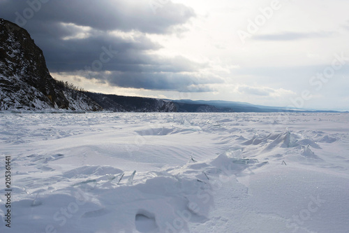 Winter landscape, Crystal clear ice chunks, icicles,Lake Baikal, Siberia, Russia. Sunny winter day weather, ice cracks, clear water, slippy and cold frozen ground.Beautiful wallpaper with nature scene © Анастасия Конева