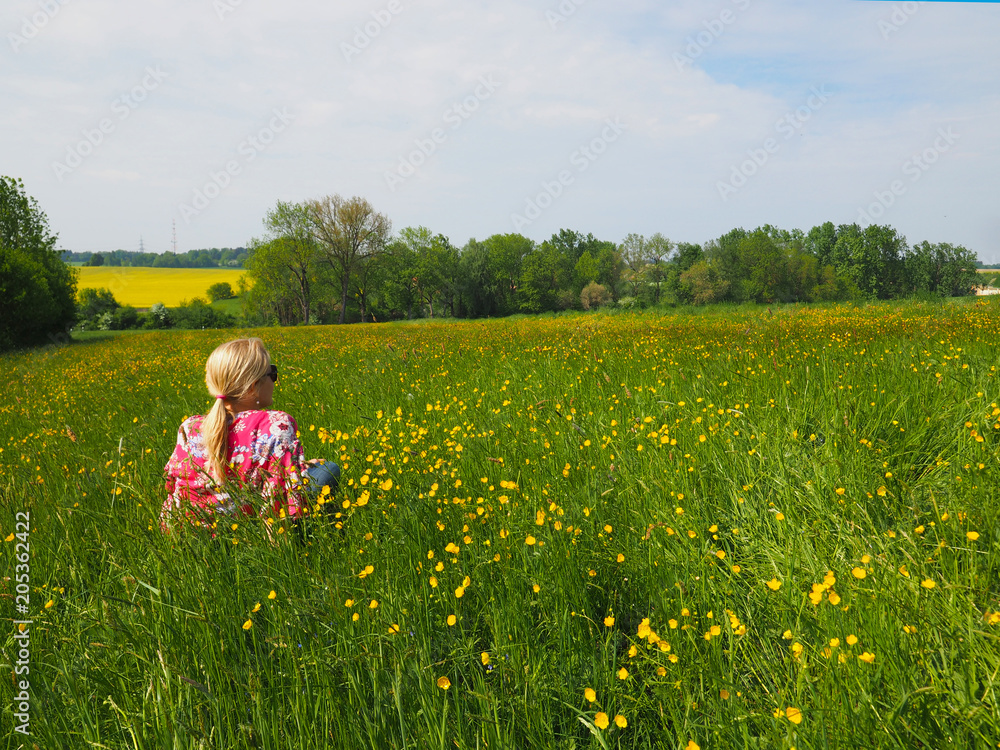 Fototapeta premium Frau sitzt auf einer Blumenwiese