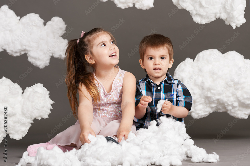 child playing with clouds, shot in the studio on a gray background child playing with clouds, shot in the studio on a gray background